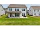 Backyard featuring a covered patio, sliding glass doors, and a well maintained lawn at 7651 Fenn Way, Fort Mill, SC 29707