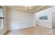 An elegant dining room features wainscoting, hardwood floors, and a stylish chandelier at 7651 Fenn Way, Fort Mill, SC 29707