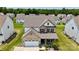 Two-story home featuring brick accents, attached garage, landscaped yard, and a cozy front porch at 7651 Fenn Way, Fort Mill, SC 29707
