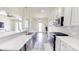 A spacious kitchen with white cabinets, subway tile backsplash, and modern appliances, with an adjacent living space at 7651 Fenn Way, Fort Mill, SC 29707