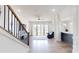 Bright living room featuring modern design, and adjacent staircase and kitchen for convenient access at 7651 Fenn Way, Fort Mill, SC 29707