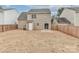 View of the back exterior features a fenced backyard, a door to the outside, and a sliding glass door to patio at 7806 Mcgarry Trl, Charlotte, NC 28214