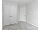 Empty bedroom featuring neutral walls, plush carpet, and a double door closet at 7806 Mcgarry Trl, Charlotte, NC 28214