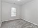 Empty bedroom featuring neutral walls, plush carpet, and a window providing natural light at 7806 Mcgarry Trl, Charlotte, NC 28214