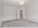 Neutrally decorated bedroom with a modern light fixture and door to the hallway at 7806 Mcgarry Trl, Charlotte, NC 28214