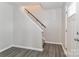 Hallway view featuring hardwood floors and a staircase with a black banister at 7806 Mcgarry Trl, Charlotte, NC 28214
