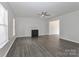Spacious living room featuring wood-look floors, a fireplace, and a ceiling fan at 7806 Mcgarry Trl, Charlotte, NC 28214