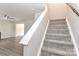 Carpeted staircase with white railing leading from the living area to the upper level at 7806 Mcgarry Trl, Charlotte, NC 28214