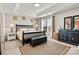 This is a staged bedroom with a large bed, tray ceiling, dresser and natural light at 8002 Mariners Pointe Cir, Denver, NC 28037