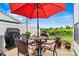 Inviting patio area featuring a red umbrella, table, chairs, and grill for outdoor relaxation and entertaining at 8002 Mariners Pointe Cir, Denver, NC 28037