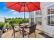 Cozy patio with a red umbrella, outdoor seating, and view of lush greenery, perfect for relaxation and entertaining at 8002 Mariners Pointe Cir, Denver, NC 28037