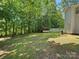 Large backyard featuring a well-manicured lawn, mature trees, and an outdoor storage shed at 8030 Glencannon Dr, Charlotte, NC 28227