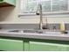 Close up of a stainless steel sink and faucet in a cozy kitchen with green cabinets at 8030 Glencannon Dr, Charlotte, NC 28227