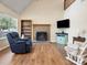 Bright living room with a brick fireplace, wood floors, and a vaulted ceiling at 8030 Glencannon Dr, Charlotte, NC 28227