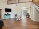 Bright living room with a flat screen TV, wood floors, and a rocking chair at 8030 Glencannon Dr, Charlotte, NC 28227