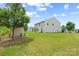 A view of the backyard shows a large lawn and a small shed and the rear of the house at 8400 Empress Ct, Charlotte, NC 28227