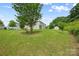 A view of the backyard shows a large lawn and a small shed and partial view of the covered porch at 8400 Empress Ct, Charlotte, NC 28227
