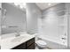 Bright bathroom featuring a single sink vanity, toilet and shower over tub with white tile surround at 8400 Empress Ct, Charlotte, NC 28227