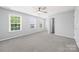 Sunlit bedroom features plush carpet, neutral walls, ceiling fan and natural light from three windows at 8400 Empress Ct, Charlotte, NC 28227