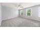 Bright bedroom with neutral walls, plush carpet, ceiling fan, and natural light from the windows at 8400 Empress Ct, Charlotte, NC 28227