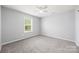 This is a bright bedroom with neutral walls, plush carpet, and a ceiling fan at 8400 Empress Ct, Charlotte, NC 28227