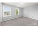 This bedroom has neutral walls, plush carpet, and natural light from the large double windows at 8400 Empress Ct, Charlotte, NC 28227