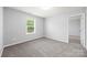 This is a bedroom with neutral walls, plush carpet, and natural light from the window at 8400 Empress Ct, Charlotte, NC 28227