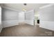 An open dining and living space with neutral paint, crown molding, wainscoting and modern lighting at 8400 Empress Ct, Charlotte, NC 28227