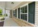 Exterior showcasing a covered front porch with brick accents and decorative green shutters at 8400 Empress Ct, Charlotte, NC 28227