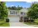 Charming two-story home with a two car garage, well-maintained lawn, and mature tree at 8400 Empress Ct, Charlotte, NC 28227