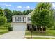 Beautiful home exterior featuring a manicured lawn, mature tree, and two-car garage at 8400 Empress Ct, Charlotte, NC 28227