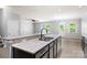 Open-concept kitchen with granite countertops and stainless sink overlooks a dining area with outdoor access at 8400 Empress Ct, Charlotte, NC 28227