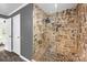Modern shower features stone walls, a rain shower head, and frameless glass doors in this upscale bathroom at 8632 Island Point Rd, Sherrills Ford, NC 28673