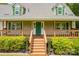 Home with a covered front porch, complemented by well-manicured landscaping and a welcoming green front door at 8632 Island Point Rd, Sherrills Ford, NC 28673