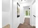 Upstairs hallway with art, leading to a bedroom with natural light from large windows at 8632 Island Point Rd, Sherrills Ford, NC 28673