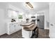 Bright kitchen features white cabinetry, stainless steel appliances, and a unique tiered island with breakfast bar at 8632 Island Point Rd, Sherrills Ford, NC 28673