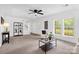 Bright living room featuring large windows, ceiling fan, neutral carpet, and modern decor at 8632 Island Point Rd, Sherrills Ford, NC 28673