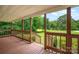 A covered porch that offers outdoor relaxation and views of the surrounding greenery and backyard at 8632 Island Point Rd, Sherrills Ford, NC 28673