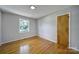 Bright bedroom with hardwood floors, gray walls, and a view of lush greenery outside the window at 967 Hilldale Dr, Lancaster, SC 29720