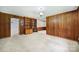Spacious living room featuring wood paneling, carpet, and a built-in bookshelf at 967 Hilldale Dr, Lancaster, SC 29720