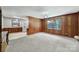 Living room with neutral carpeting and wood paneling connecting to eat-in kitchen at 967 Hilldale Dr, Lancaster, SC 29720