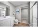 Bright bathroom features a white vanity, shower, and a walk-in closet for ample storage at 10127 Florentine Way, Charlotte, NC 28214