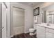 Full bathroom featuring a toilet, sink, and shower, with a view into a walk-in closet with wire shelving at 10127 Florentine Way, Charlotte, NC 28214