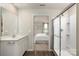 Bathroom featuring a glass-enclosed shower, white vanity with sink, and a glimpse into the Primary bedroom at 10127 Florentine Way, Charlotte, NC 28214