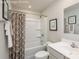 Bathroom featuring a shower/tub combo with a patterned shower curtain, a sink and vanity, and neutral decor at 10127 Florentine Way, Charlotte, NC 28214