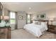 Comfortable bedroom with soft carpet, large windows with patterned curtains, and a padded headboard on the bed at 10127 Florentine Way, Charlotte, NC 28214