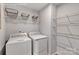 A laundry room with a full-sized washer and dryer and metal shelving units, ready for lots of storage at 10127 Florentine Way, Charlotte, NC 28214