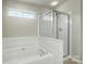 An elegant bathroom includes a large soaking tub and a glass-enclosed shower at 10225 Alexander Martin Ave, Charlotte, NC 28277