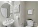 Half bathroom features a pedestal sink, rounded mirror, and stylish fixtures at 10225 Alexander Martin Ave, Charlotte, NC 28277