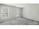 A secondary bedroom features a plush carpet and two large windows at 10225 Alexander Martin Ave, Charlotte, NC 28277